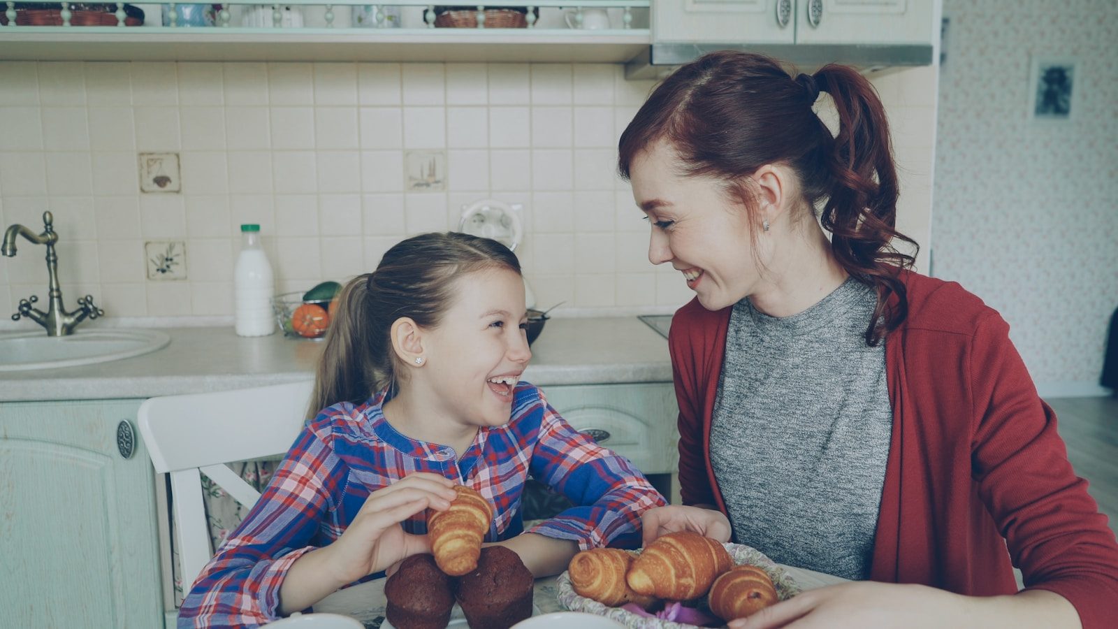 Two girls enjoying breakfast together at the table.